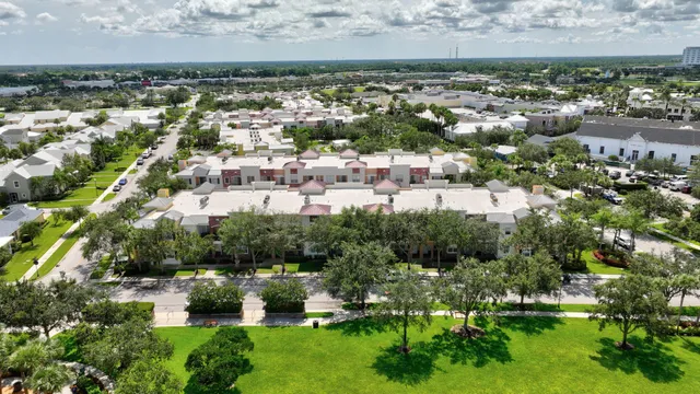 an aerial view of a city with lots of residential buildings ocean and mountain view in back