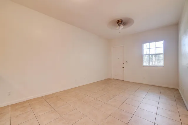 an empty room with windows and fan