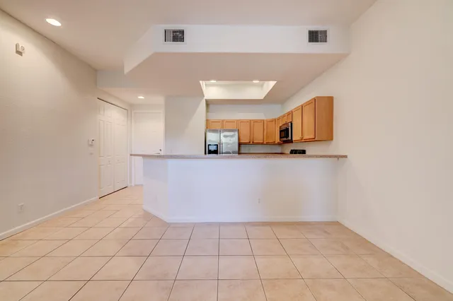 a view of kitchen with stainless steel appliances a refrigerator and microwave