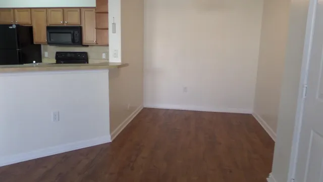 a view of a kitchen with wooden floor and electronic appliances
