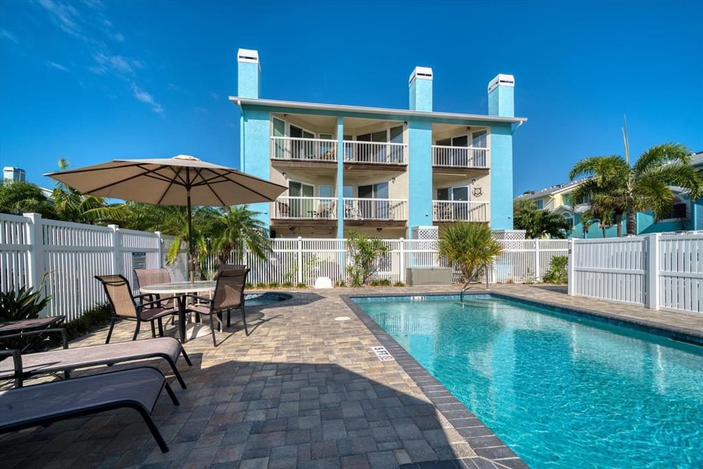 124 Marcdale Boulevard Indian Rocks Beach, FL 33785 - Photo 24 of 55 a view of a patio with chairs and table under an umbrella