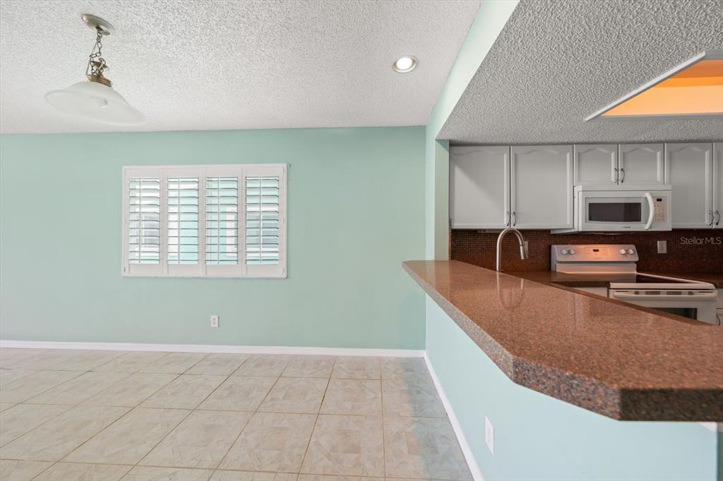 124 Marcdale Boulevard Indian Rocks Beach, FL 33785 - Photo 9 of 55 a kitchen with stainless steel appliances granite countertop a sink a stove and a refrigerator