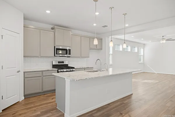 a kitchen with stainless steel appliances granite countertop a sink a stove and a refrigerator