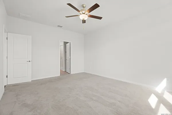 an empty room with closet and fan