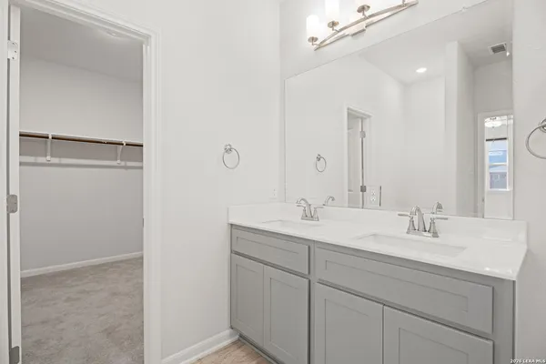 a bathroom with a double vanity sink and mirror