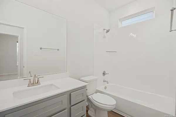 a bathroom with a granite countertop sink toilet a mirror and shower