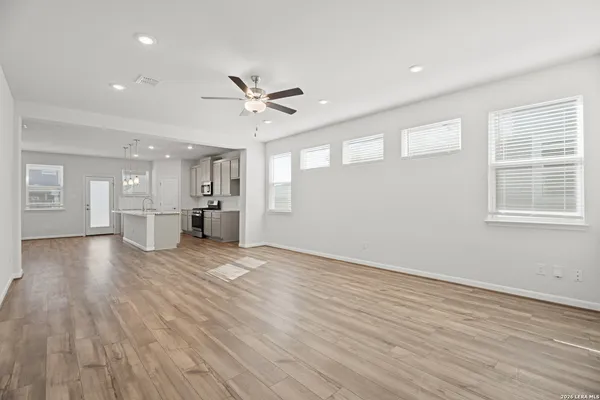 a view of an empty room with a window and wooden floor