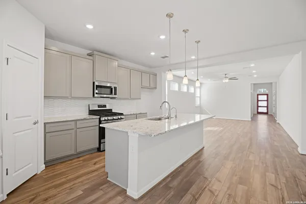 a kitchen with kitchen island a sink stainless steel appliances and cabinets