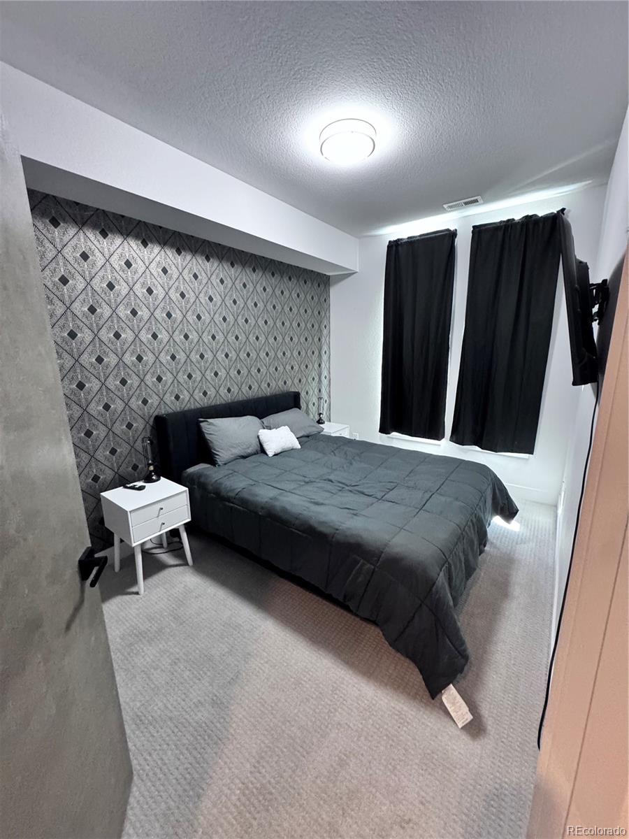 931 33rd Street Denver, CO 80205 - Photo 2 of 16 a bedroom with a bed and a black furniture
