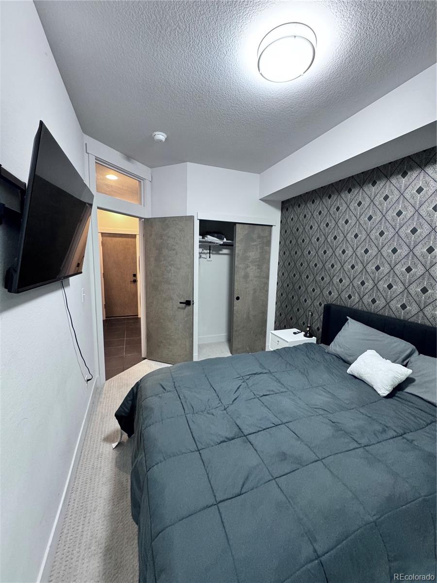 931 33rd Street Denver, CO 80205 - Photo 3 of 16 a bedroom with a bed and a television
