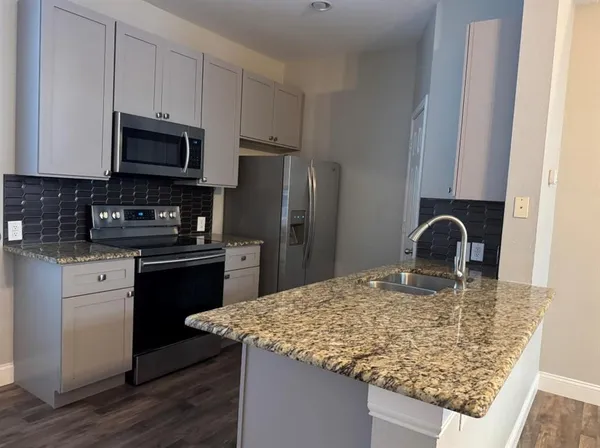 a kitchen with stainless steel appliances granite countertop a sink stove and refrigerator
