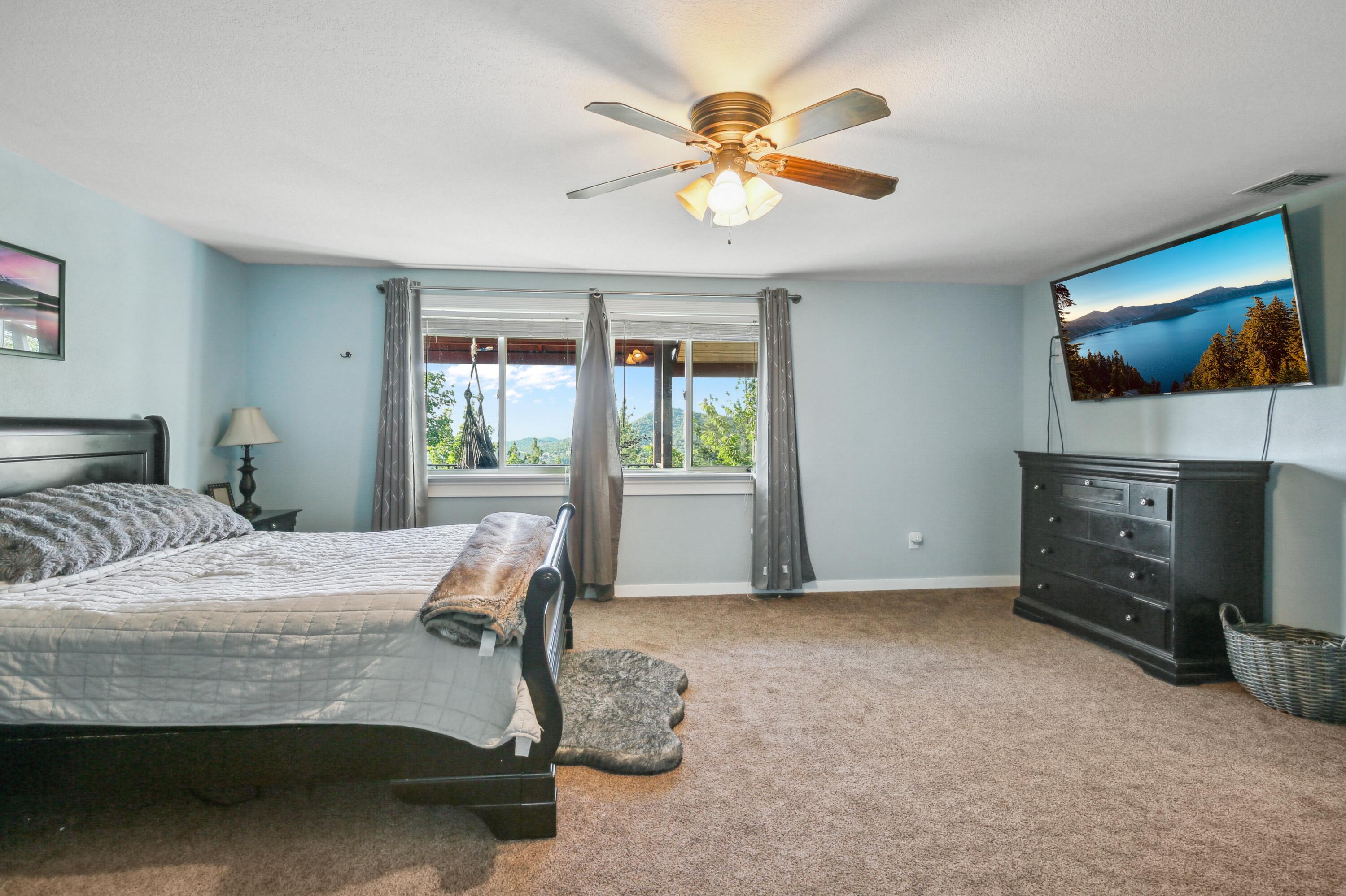 448 Wren Ridge Drive Eagle Point, OR 97524 - Photo 18 of 45 a bedroom with a bed and a flat screen tv