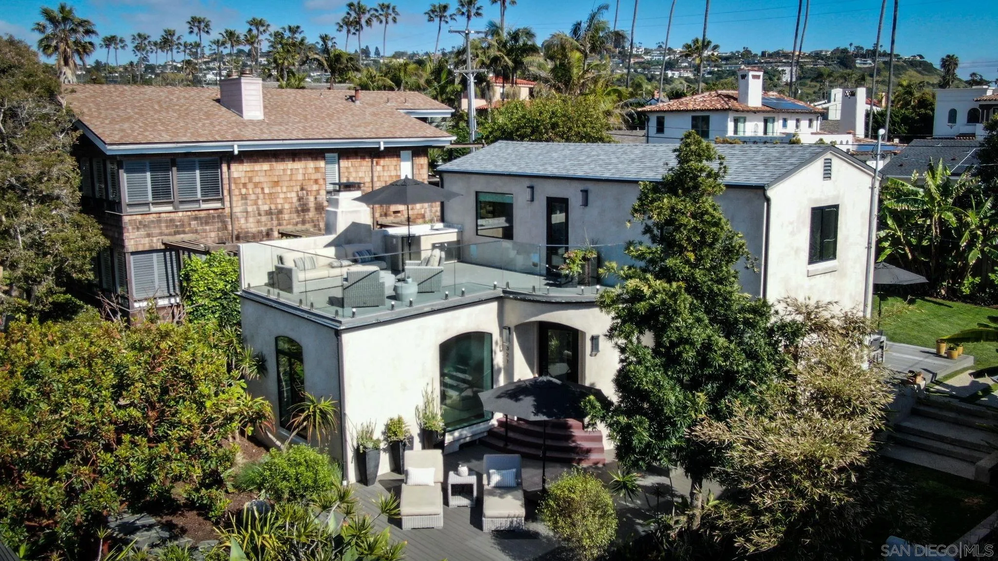 321 Fern Glen La Jolla, CA 92037 - Photo 37 of 46 a view of a white house with a chairs and table in a patio