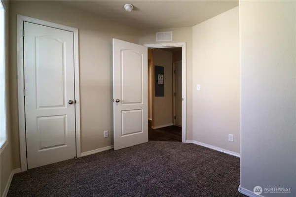 an empty room with closet and a bathroom