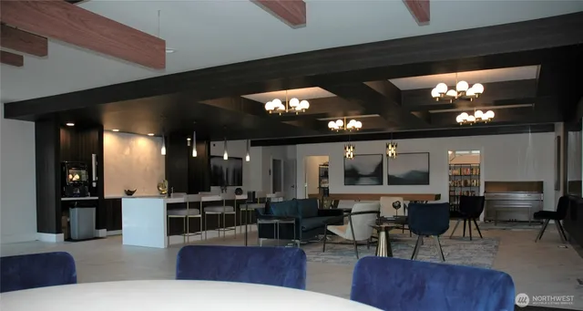 a living room with lots of furniture a chandelier and kitchen view