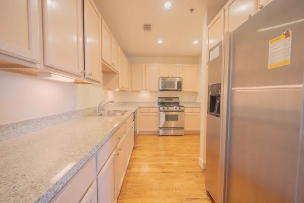 a kitchen with granite countertop a sink and stainless steel appliances
