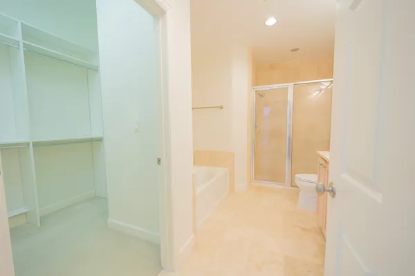 a bathroom with a granite countertop sink a toilet and shower