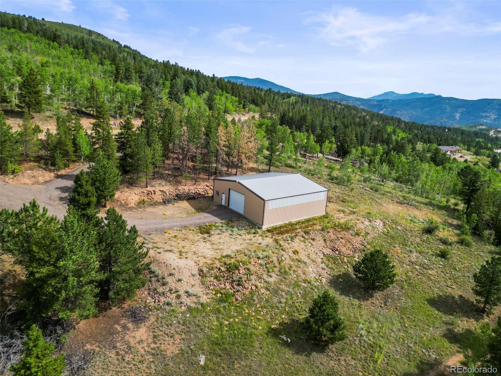 6660 Virginia Canyon Road Central City, CO 80427 - Photo 4 of 31 a view of a house with a mountain yard and a forest