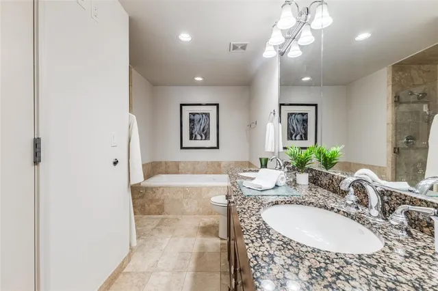 a bathroom with a granite countertop sink a mirror and a shower