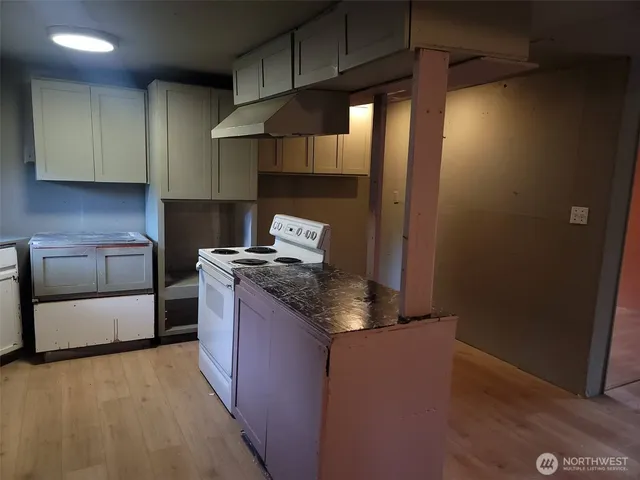 a kitchen with granite countertop a sink stove and cabinets