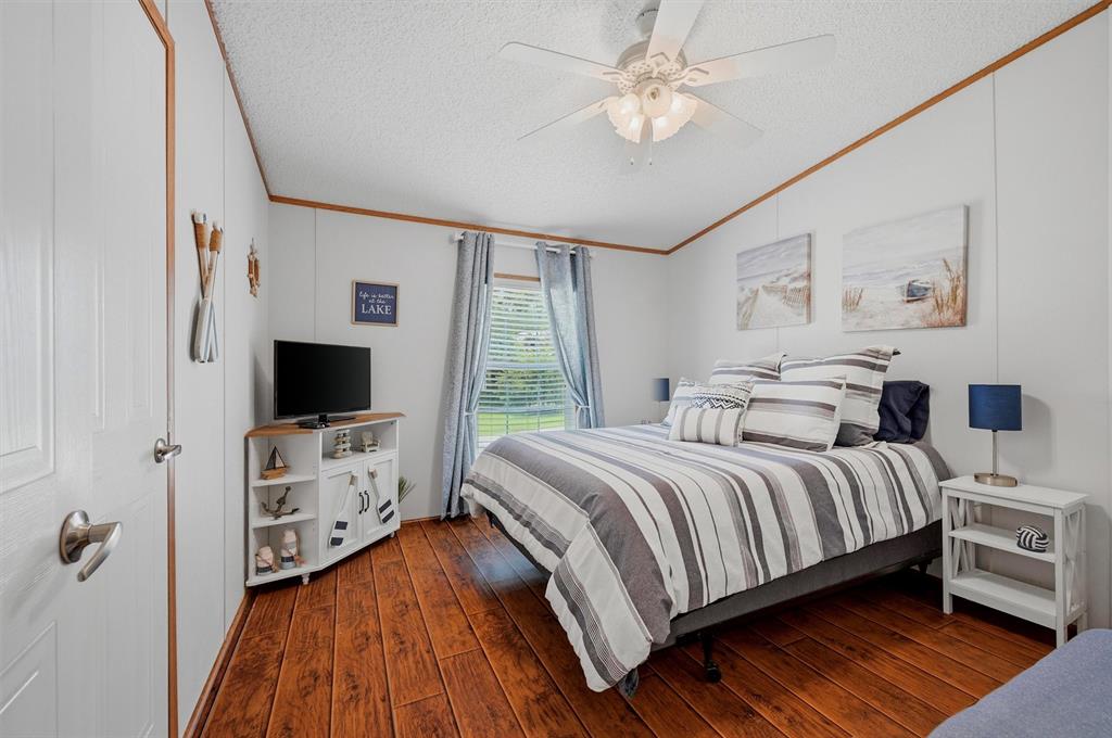 212 Sunset Road Pottsboro, TX 75076 - Photo 17 of 40 a bedroom with a bed and a flat tv screen on dresser