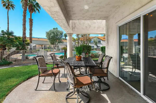 a view of a patio with a table chairs and garden