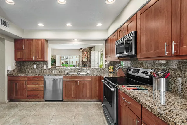 a kitchen with stainless steel appliances granite countertop a stove sink microwave and cabinets