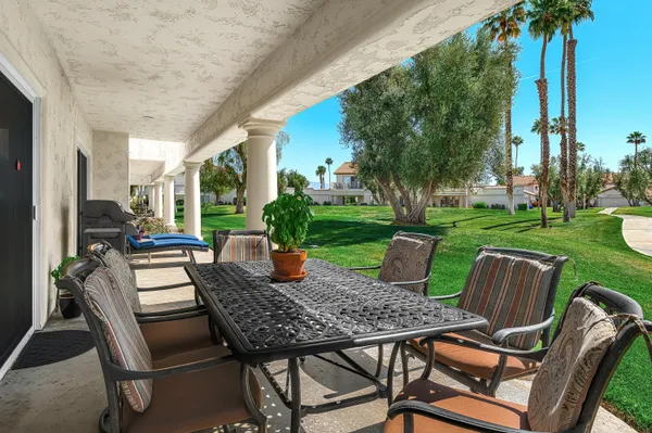 a view of a patio with a table chairs and a backyard