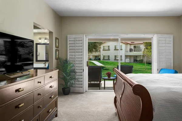 a living room with furniture a flat screen tv and a floor to ceiling window