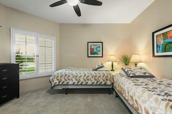 a bedroom with two beds and painting on the wall