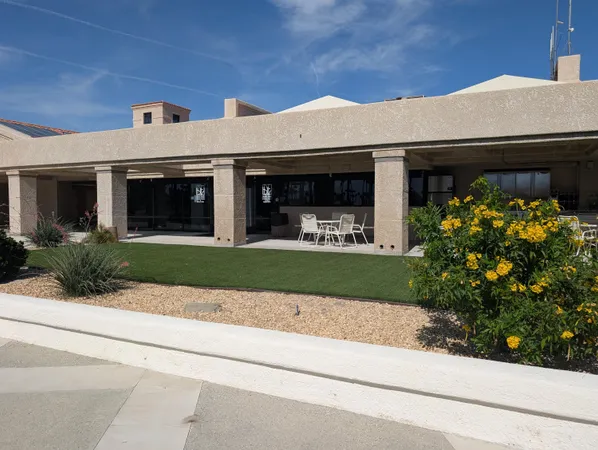 a front view of a house with a garden and plants