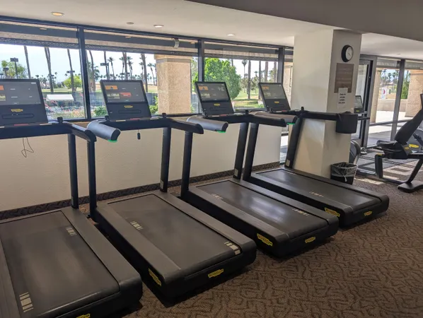 a room with gym equipment and large windows