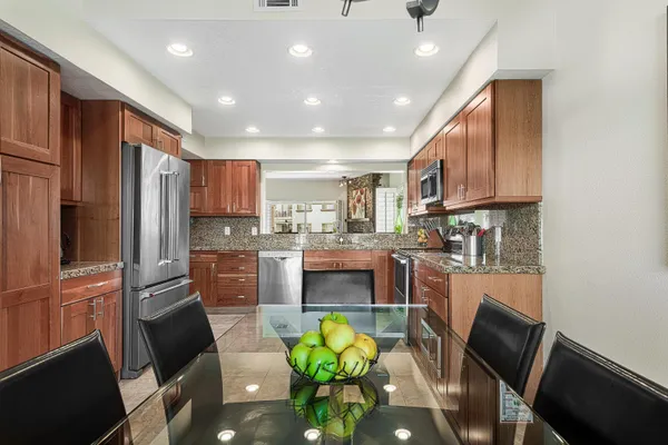 a kitchen with stainless steel appliances granite countertop a refrigerator and a stove top oven