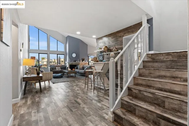 a living room with furniture a fireplace a rug and a large window
