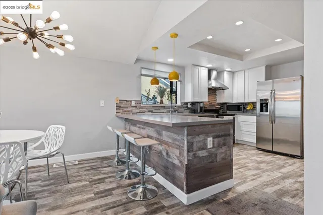 a kitchen with a table chairs refrigerator and microwave