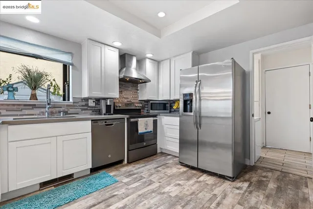 a kitchen with stainless steel appliances a refrigerator sink and microwave