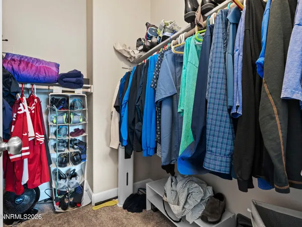 a view of walk in closet with clothes and shoes