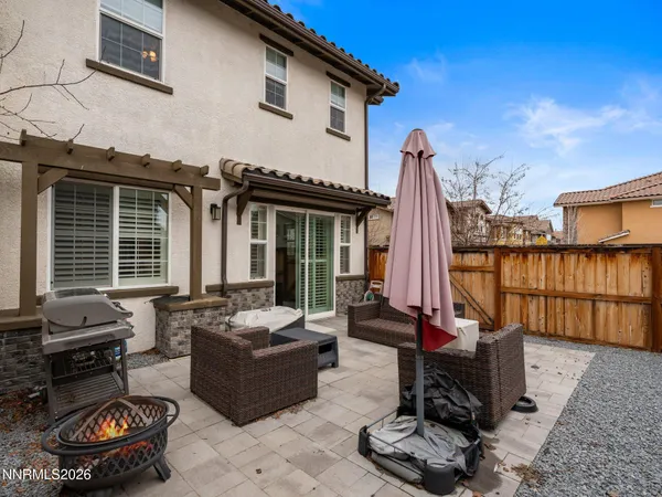 a view of a patio with couches table and chairs with wooden fence