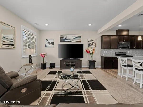 a room with furniture a flat screen tv and kitchen view