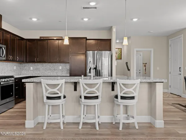 a kitchen with stainless steel appliances kitchen island granite countertop a table and chairs in it