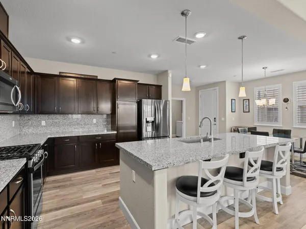 a large kitchen with granite countertop a island in the center a sink stainless steel appliances and cabinets