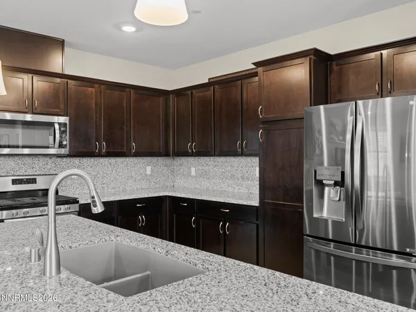 a kitchen with granite countertop a refrigerator and a sink