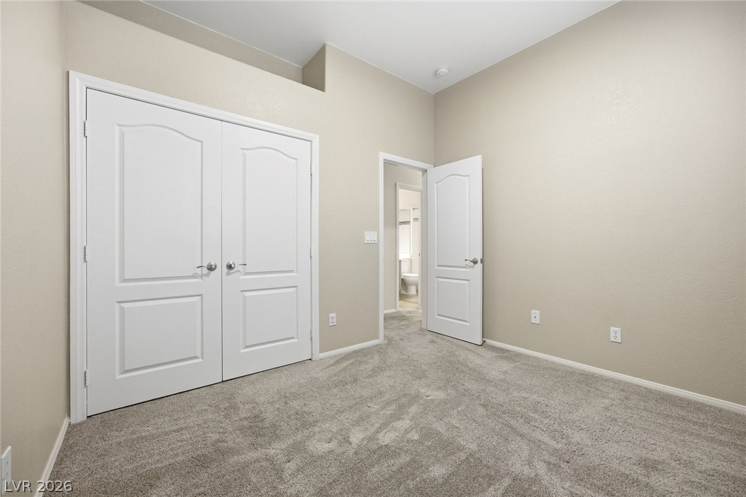 193 Oella Ridge Court Henderson, NV 89012 - Photo 24 of 32 A well-maintained bedroom offers comfort and a tranquil atmosphere with plush carpeting.