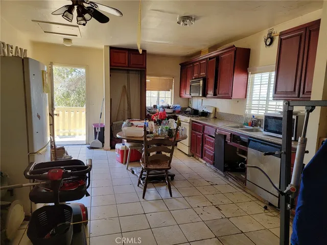 a view of a kitchen with dining area a sink stove and wooden floor