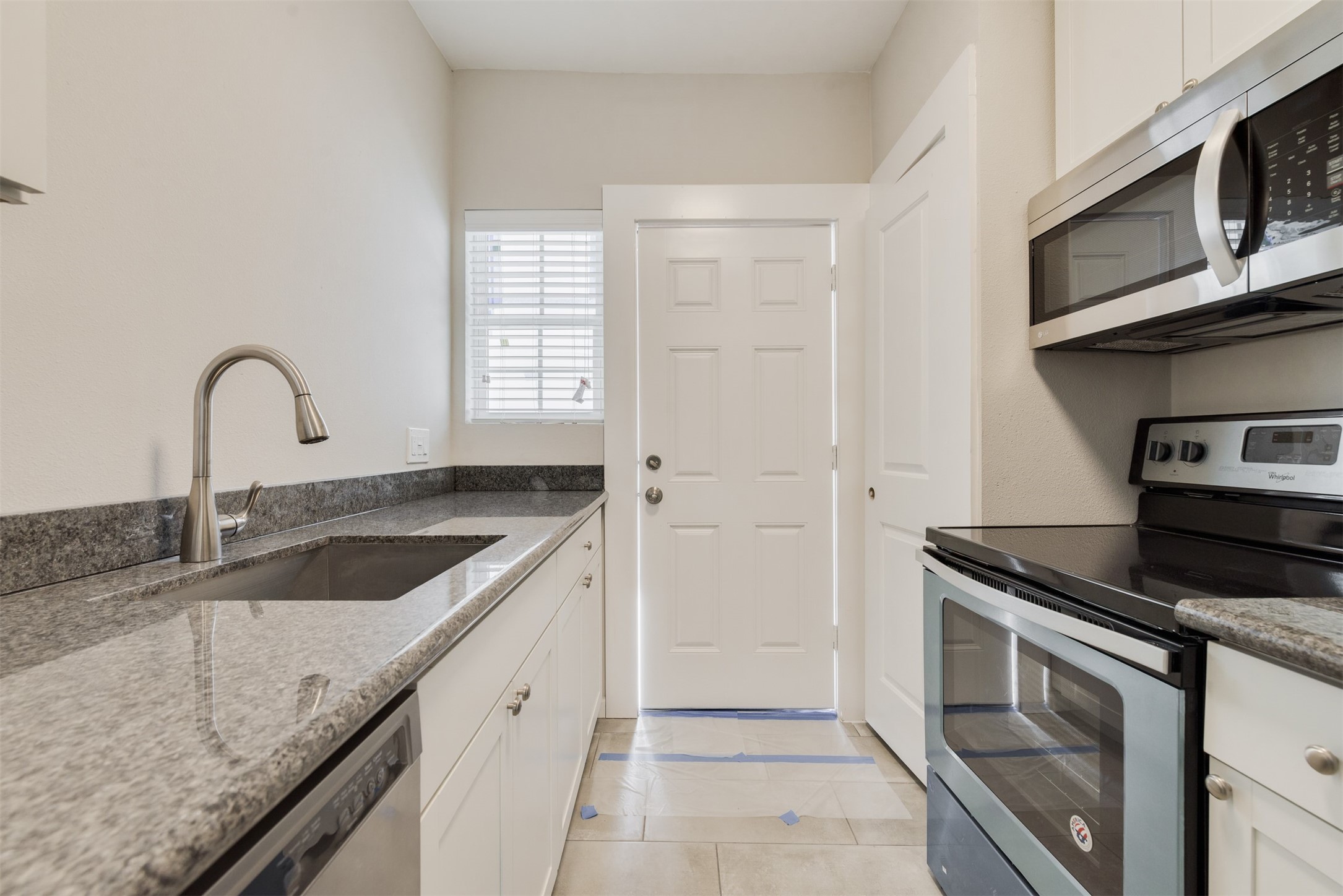 1219 West Gray Street, Unit 2 Houston, TX 77019 - Photo 18 of 25 a kitchen with granite countertop a sink stainless steel appliances and cabinets