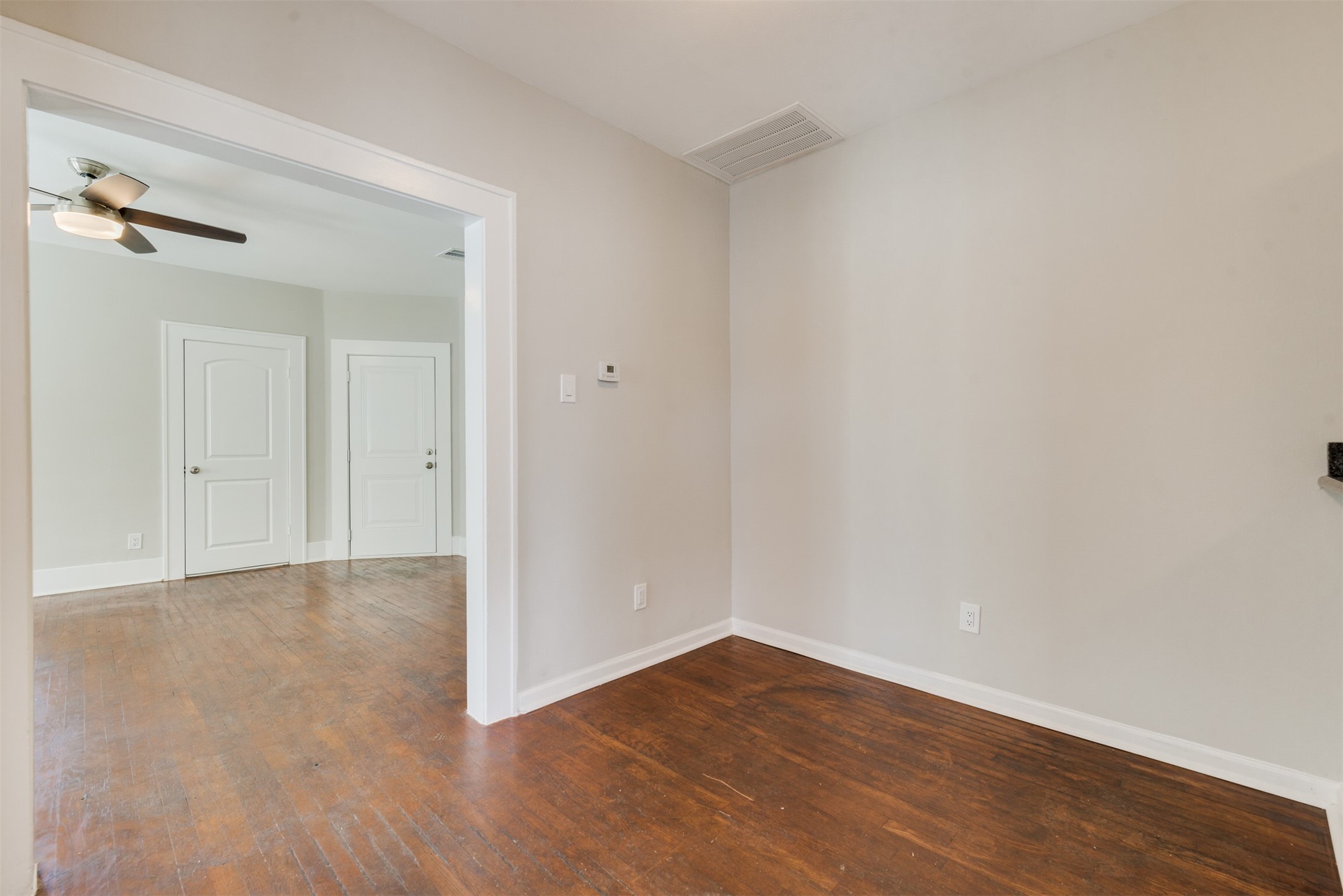 1219 West Gray Street, Unit 2 Houston, TX 77019 - Photo 21 of 25 a view of an empty room with wooden floor and a ceiling fan