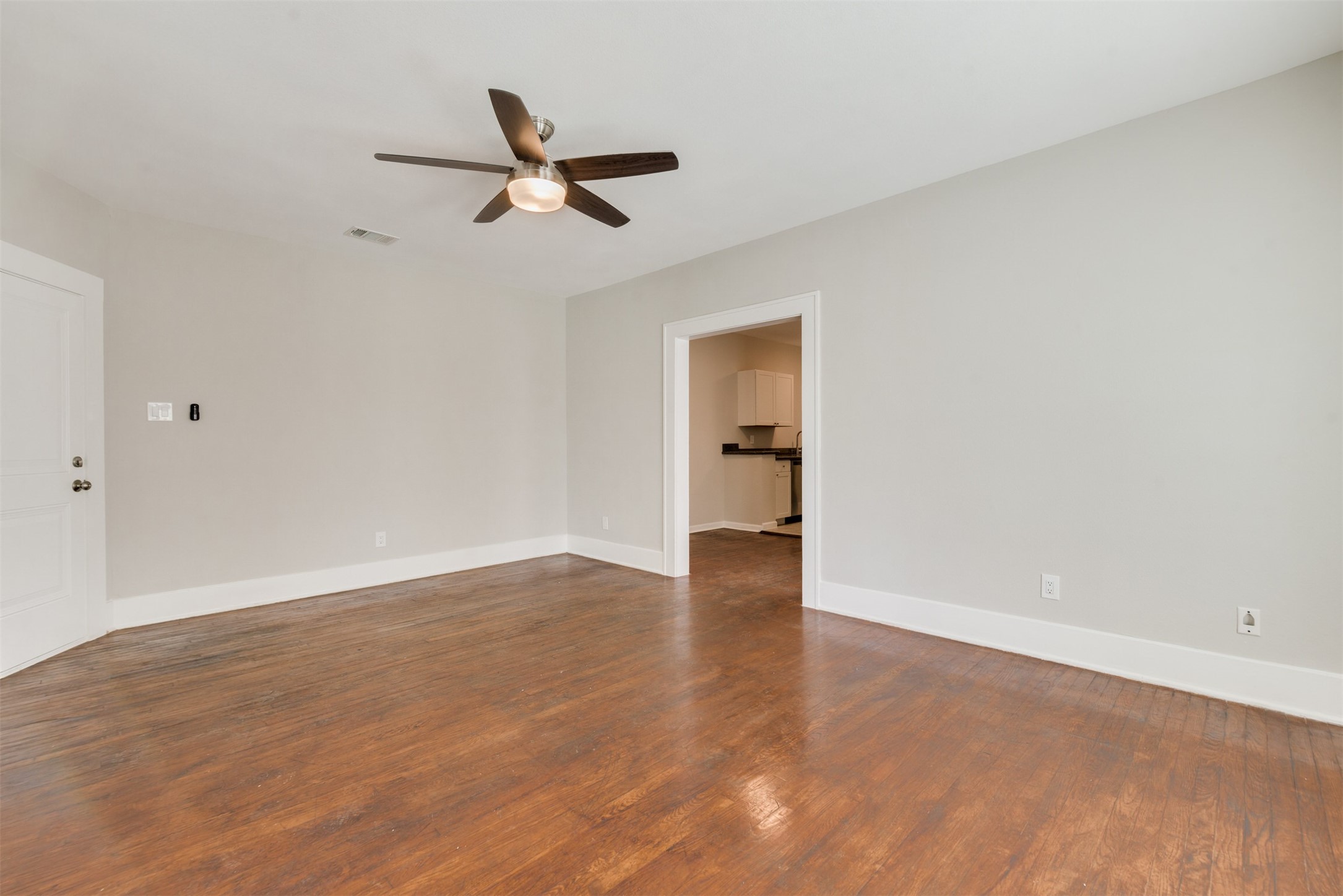 1219 West Gray Street, Unit 2 Houston, TX 77019 - Photo 5 of 25 a view of a room with wooden floor and a ceiling fan