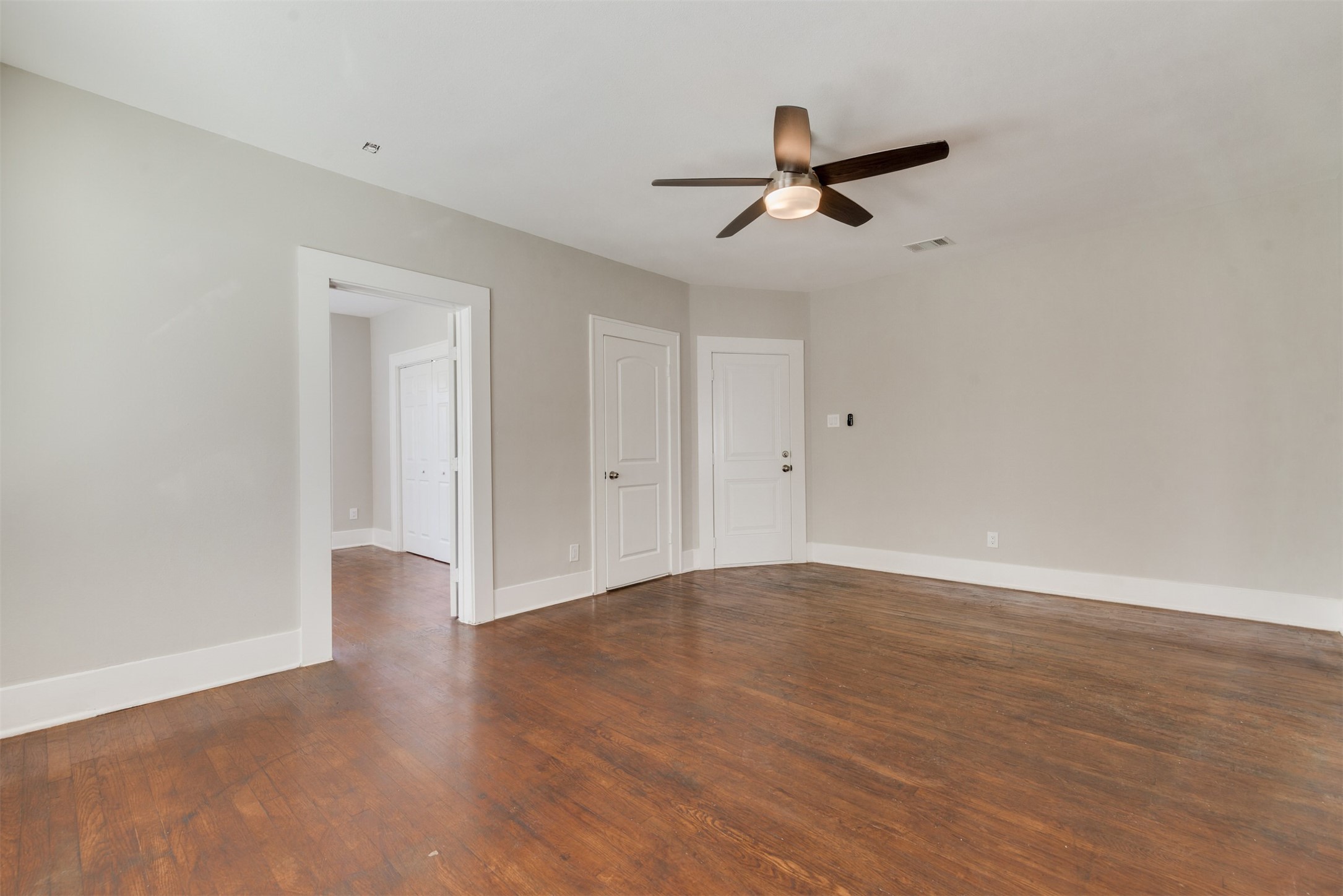 1219 West Gray Street, Unit 2 Houston, TX 77019 - Photo 7 of 25 a view of an empty room with wooden floor and a ceiling fan