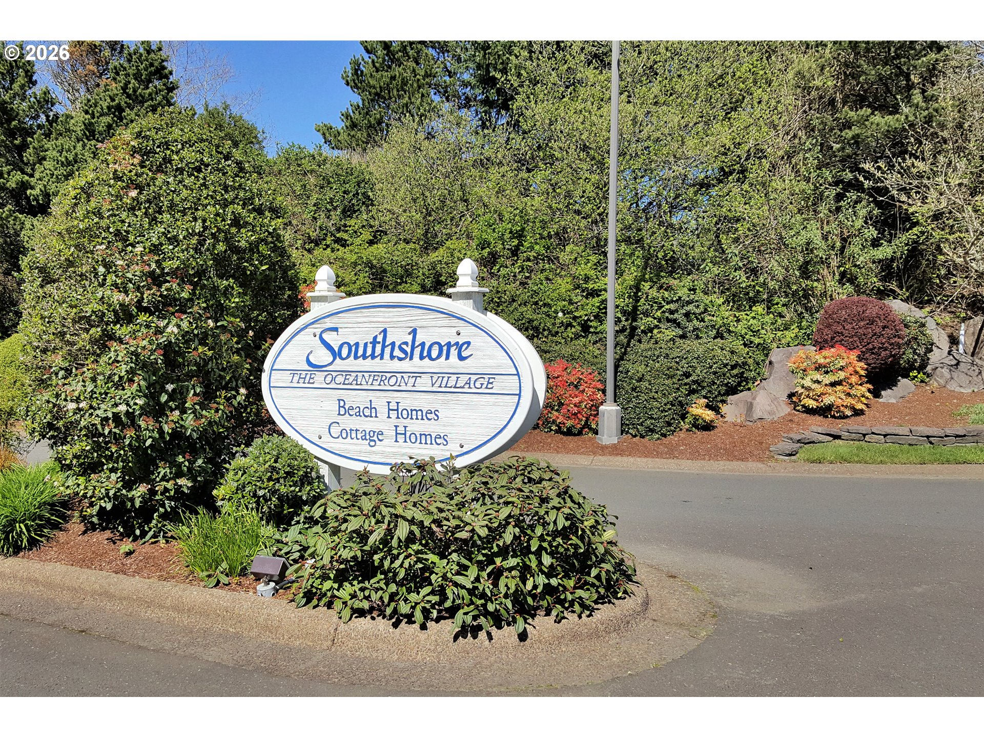 Southwest Cupola Place, Unit 132 South Beach, OR 97366 - Photo 13 of 28 a sign that is sitting in front of flowers