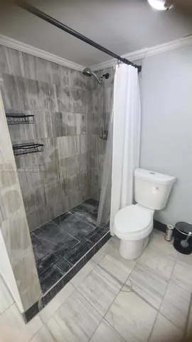 a bathroom with a toilet and a shower